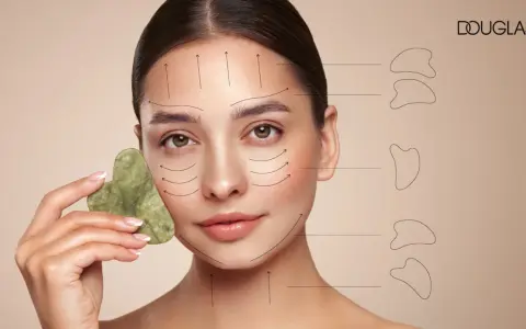 Frau mit Gua Sha Stein im Gesicht, Pfeile zeigen die Anwendungsrichtung. Entdecke, was Gua Sha bringt für deine Hautpflege.