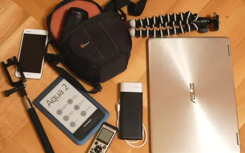 Elektronika i akcesoria podróżne: smartfon, czytnik e-booków, aparat, powerbank, laptop, selfie stick i statyw.
