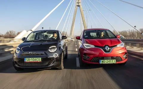 Czarny fiat elektryczny i czerwony samochód jadą po moście.