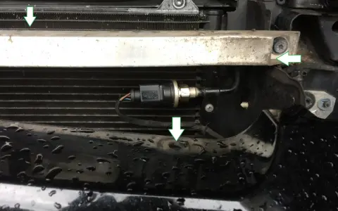 Ein Teil des Kühlergrills mit einem angeschlossenen hochdruckgeber g65. Grüne Pfeile zeigen auf Befestigungspunkte.