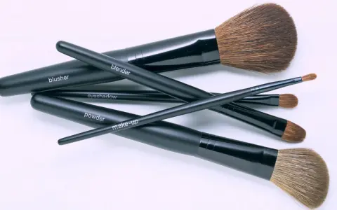 Un conjunto de brochas de maquillaje negras etiquetadas como "blusher", "blender", "eyeshadow", "powder" y "make-up". Aprende como limpiar brochas de maquillaje para mantenerlas en perfecto estado.