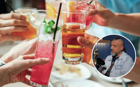 Ludzie wznoszą toasty kolorowymi drinkami. W tle mężczyzna dyskutuje, czy alkohol to narkotyk.