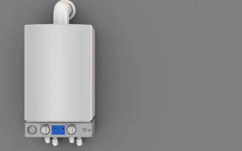 Caldaia moderna con display digitale e manometri. Il tubo scarico fumi caldaia normativa è visibile in alto, essenziale per la sicurezza.