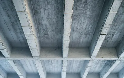 Betonowy strop z widocznymi belkami i płytami. Szukając, jaki strop najtańszy, warto rozważyć takie proste konstrukcje.
