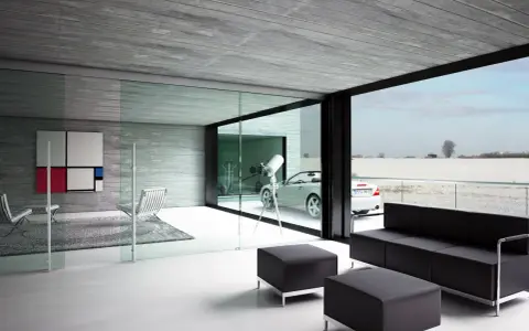 Interior moderno con sofá negro, sillones y una gran pared de cristal que da a un paisaje nevado y un coche descapotable.