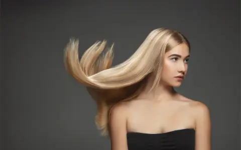 Blond włosy modelki falują, ukazując ich zdrową budowę.