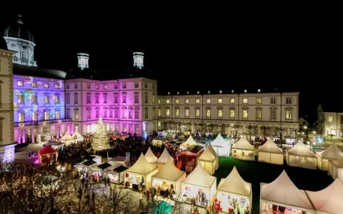 Einzigartiger Weihnachtsmarkt Bensberg vor beleuchtetem Schloss. Viele Stände und ein großer Weihnachtsbaum laden zum Bummeln ein.