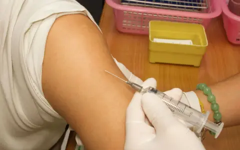 Spritze wird in den Arm einer Person eingeführt, die eine Hyposensibilisierung gegen Asthma erhält.