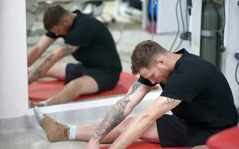 Mężczyzna wykonuje ćwiczenia na rozciąganie, które mogą pomóc w problemach z bocznym przyparciem rzepki.