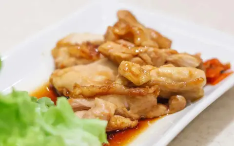 Straccetti di pollo succulenti in salsa agrodolce, serviti con insalata fresca e carote.