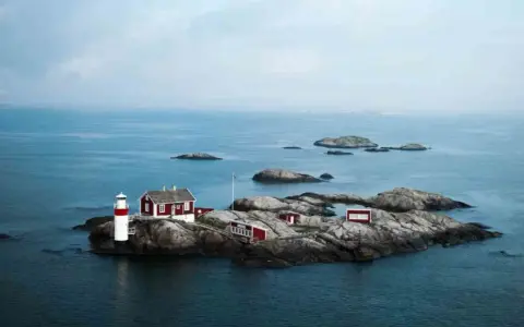 Fyren och röda hus på en klippö bland svenska öar.