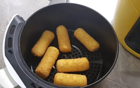 Crocchette di patate dorate e croccanti pronte per essere gustate, appena uscite dalla friggitrice ad aria.