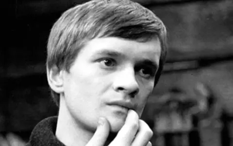 Młody Andrzej Miś, zamyślony, z palcem przy ustach. Jego życiorys to fascynująca historia.