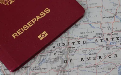 Ein roter Reisepass liegt auf einer Karte der USA. Perfekt für deinen **Gap Year USA** Traum!