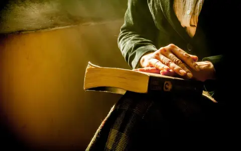 Dłonie spoczywają na książce "Córka Fortuny" Isabel Allende. Może to być streszczenie "Jądra ciemności", które skłania do refleksji.