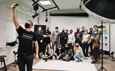 Grupa entuzjastów fotografii na zajęciach w szkole fotografii. Uczestnicy pozują do wspólnego zdjęcia w studiu.