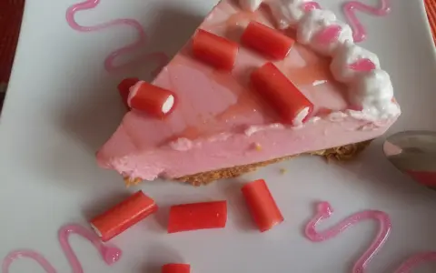 Deliciosa tarta de regaliz rojo con crema rosa y adornos de regaliz.