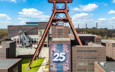 Große Fördergerüst-Struktur auf dem Gelände der Zeche Zollverein, die eine Ausstellung mit der Zahl 25 feiert.