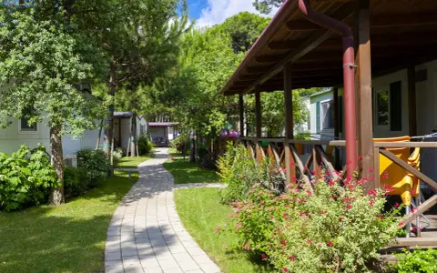 Ścieżka w ca pasquali village prowadzi wśród zieleni do domków letniskowych.