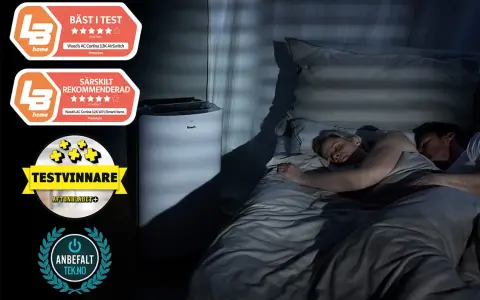 Ett par sover lugnt i mörkret medan en luftfuktare sovrum står bredvid sängen, med utmärkelser som "Bäst i test" och "Särskilt rekommenderad".