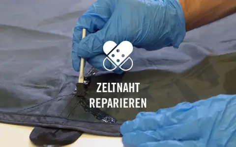 Mit einem Pinsel wird eine dunkle Dichtungsmasse auf eine Zeltnaht aufgetragen, um sie abzudichten und zu reparieren.