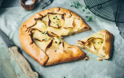 Galette aux pommes, recette de maman, dorée et garnie de fines tranches de pommes, prête à être dégustée.