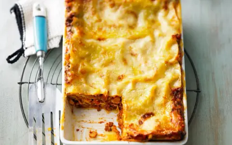 Herzhaftes Lasagne Rezept mit goldbrauner Käsekruste, bereit zum Servieren. Ein Stück fehlt bereits!