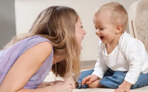 Frau und Baby lachen sich an. Sie unterhalten sich, zahlen ohne Sorgerecht, aber die Freude ist echt.