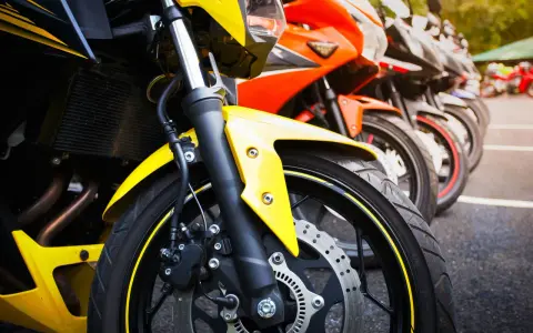 Una fila di moto sportive, tra cui una Yamaha scarenata gialla in primo piano, pronte per la corsa.