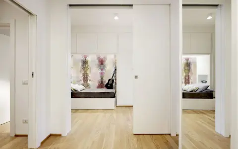 Un letto a scomparsa e una porta scorrevole creano una stanza in più, trasformando un corridoio in uno spazio accogliente.