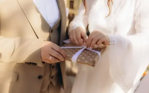 Para młoda otwiera prezent. Zastanawiasz się, ile daje się na wesele?