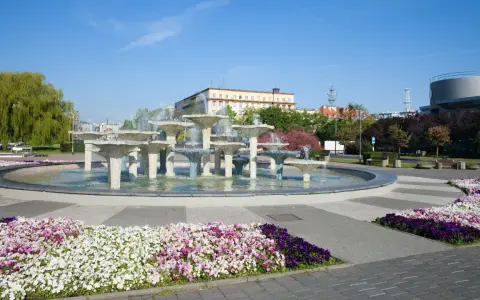 Fontanna w Gdyni stare miasto, otoczona kolorowymi kwiatami i zielenią, stanowi serce miejskiego placu.