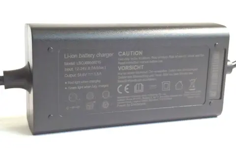 Graues Netzteil mit der Aufschrift "Output: 54.6V 1.5A". Dieses Netzteil 12V 5A ist für Li-ion Akkus.