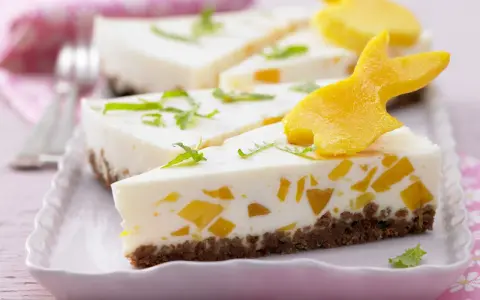 Süße Ostertorten Rezepte: Cremiger Kuchen mit Mango-Stückchen und Osterhasen-Deko aus Mango.
