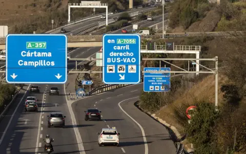 Carril derecho BUS-VAO en A-7056, con distintivo ambiental B. Señalización de tráfico en autopista.