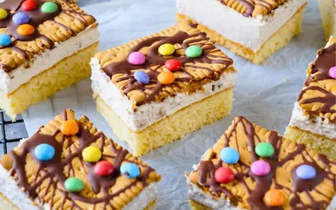 Bunte Geburtstagskuchen für Kinder, dekoriert mit Keksen, Schokolade und bunten Smarties.