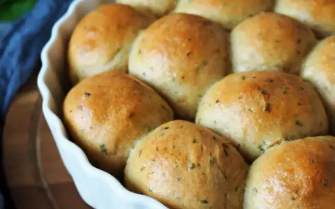 Frisch gebackene, goldbraune Brötchen mit Kräutern, bereit zum Genießen. Ein perfektes kleines Brot backen für jeden Anlass.