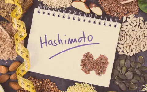 Czy hashimoto skraca życie? Notatnik z napisem "Hashimoto", taśma miernicza i zdrowe nasiona.