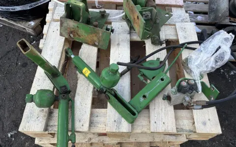 Części do amortyzacji kabiny John Deere: siłownik, wsporniki i elementy hydrauliczne.