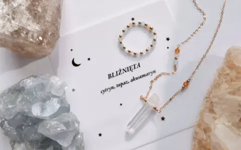 Delikatna biżuteria z kamieniami, w tym akwamaryn, otoczona surowymi kryształami.