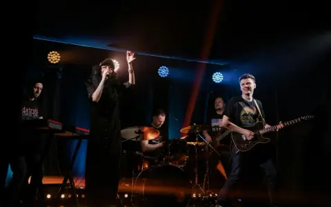 Zespół rockowy na scenie: wokalistka, gitarzysta, basista, perkusista i klawiszowiec. Koncert jak z listy zespoły rockowe zagraniczne alfabetycznie.