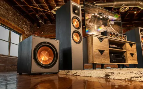 Idealne ustawienie subwoofera i głośników w industrialnym salonie. Ciemne kolumny i subwoofer z miedzianymi membranami tworzą stylowy zestaw audio.