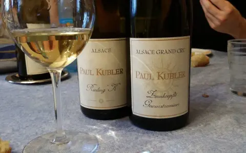 Verre de vin blanc et deux bouteilles Paul Kubler, Riesling et Gewurztraminer. Quel vin pour cuire la choucroute ? Le Gewurztraminer est un excellent choix.