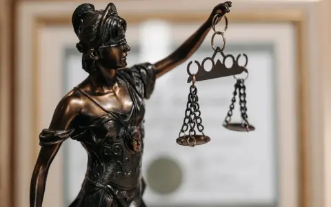 Statua della Giustizia con bilancia, simbolo di chi ha conseguito la laurea in legge o giurisprudenza.