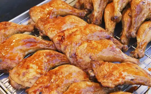 Une belle rangée de pilons de poulet rôtis, brillants d'une sauce caramélisée, prêts à être dégustés.