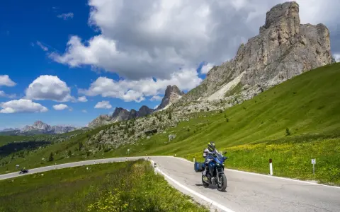 Motociclista su strada panoramica tra le montagne, un invito a scoprire le **strade da fare in moto** con panorami mozzafiato.