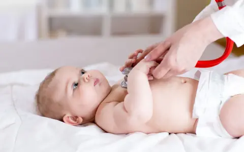 Lekarz osłuchuje niemowlę stetoskopem. Badanie może pomóc w wykryciu chorób metabolicznych u dzieci, lista schorzeń jest długa.