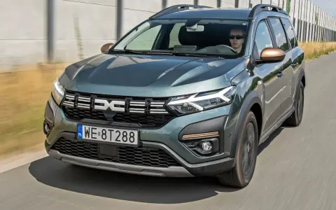 Dacia Jogger w zielonym kolorze jedzie po drodze. Sprawdź atrakcyjną dacia jogger cena i wybierz swój wymarzony samochód.