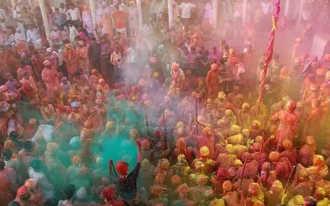 Tłum ludzi w kolorowym pyle podczas festiwalu Holi. To jedno z wielu barwnych festiwali na świecie, pełne radości i tradycji.