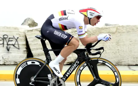 Cyclist in full aerodynamic gear, focused on time trial training, pushing hard on a specialized bike.